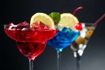 Colorful cocktails and dry martini with green olives.