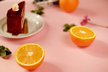 orange fruit top view with cake on pink background.