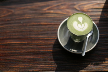 matcha green tea cup on wood from top view.