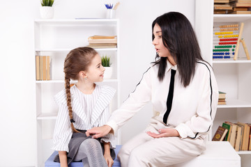 Fototapeta premium Female psychologist counseling little girl in the cabinet