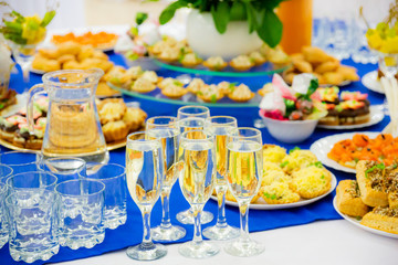 White sparkling wine in glasses. Festively laid tables at the Banquet. Various delicacies, snacks and drinks. Catering.