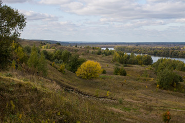 Fototapeta na wymiar Autumn panoramic landscape with river and hills cloudy day in Konstantinovo village Russia