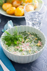 Okroshka with mineral water sausage in a bowl, selective focus