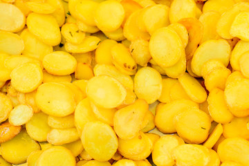 Large portion of freshly fried potato chips, available for sale at a street food market, selective focus