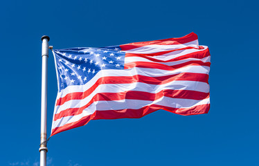 Fototapeta premium USA Flag and blue Sky as Background, American Flag waving on flagpole, New York
