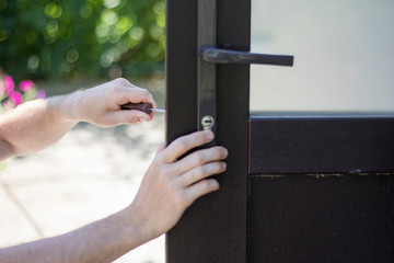 Handyman installing and repair the lock in front the plastic door.