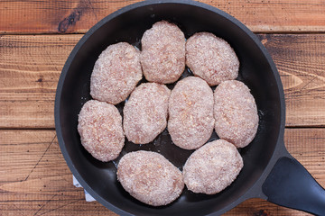 Step-by-step preparation of homemade turkey cutlets with cheese filling, step 4 - frying the cutlets in a pan, top view, selective focus