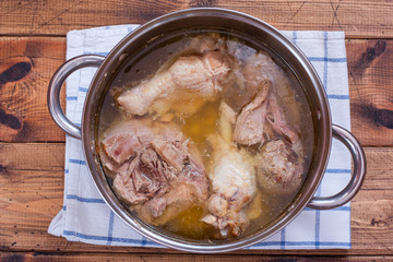 Step-by-step cooking of homemade turkey jelly, step 1 - boiling meat, top view, selective focus