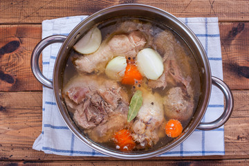 Step-by-step cooking of homemade turkey jelly, step 2 boiling meat with vegetables, top view, selective focus