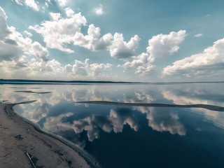 Amazing landscape of the sea with reflection in the water the white clouds.