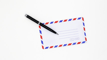Airmail envelope and black pen on white background.