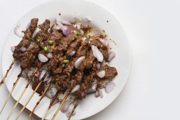 chicken satay with peanut sauce on dish isolated white background