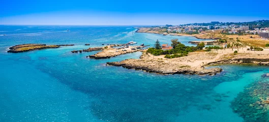 Poster Panorama of Cyprus on a Sunny day. The mediterranean coast. The Port Of Pernera. There's a yacht in the Harbor. The house with a brown roof is located on a picturesque Cape. Rest, vacation, relaxation © Grispb