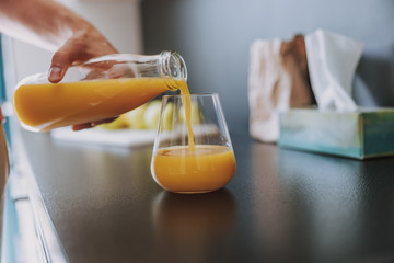 Man pouring orange juice into the glass
