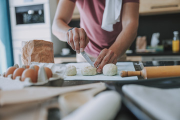 Obraz na płótnie Canvas Cook preparing scones for putting in the oven