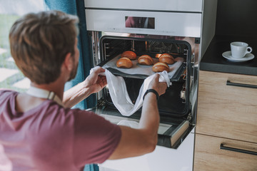 Cook carefully taking baking from the oven