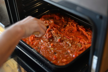 Baked tomato dish with bell pepper. Shakshuka with tomatoes and vegetables. Bake in the oven in deco. Cooking process in the kitchen