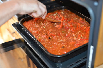 Baked tomato dish with bell pepper. Shakshuka with tomatoes and vegetables. Bake in the oven in deco. Cooking process in the kitchen