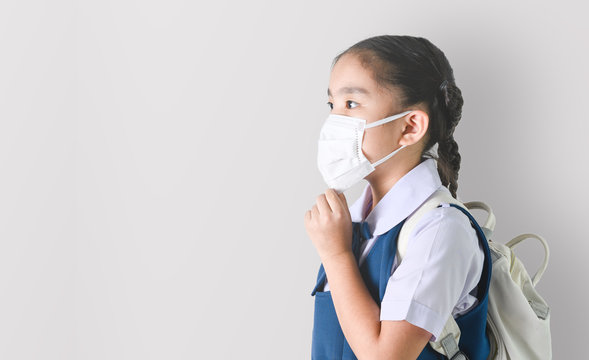 School Girl wearing mouth mask against air smog pollution on Gray background with clipping path
