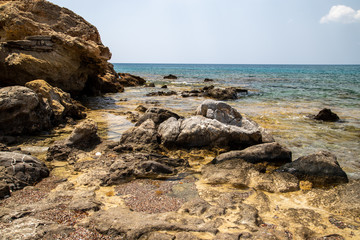 Fototapeta na wymiar Rocky coastline at the beach of Kiotari on Rhodes island, Greece in summer at a sunny day