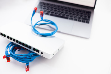 Smart office concept.  Silver switch and new laptop on the white background. Network configuration...