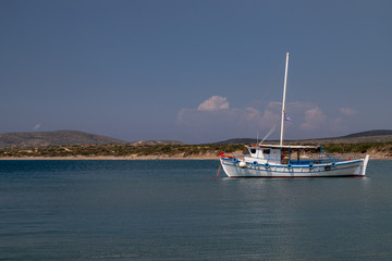 Fototapeta na wymiar Fishing boat in the bay of Plimmiri at Rhodes island, Greece and mountain range in the background on a sunny day in summer