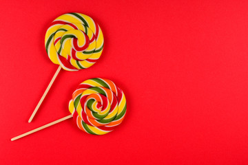 Colorful candy on a red  background. Lollipop. Top view. Copy space.