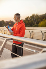 Contented sportive man with a bottle of water