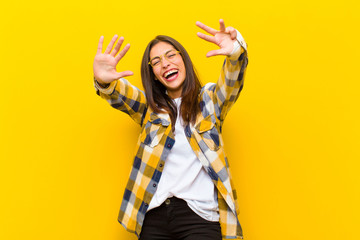 young  pretty woman smiling and looking friendly, showing number nine or ninth with hand forward,...