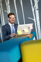 Fototapeta premium Young employee working on computer during working day in office