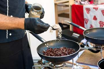 Chef preparing delicious organic pasta dish outdoor.