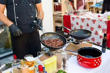 Chef preparing delicious organic pasta dish outdoor.