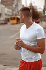 Sportsman with a bottle of water looking away
