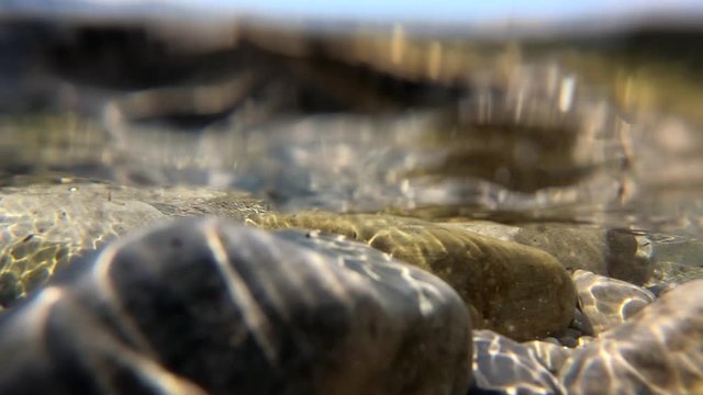 Slow motion sea waves hitting and flooding rocky shore