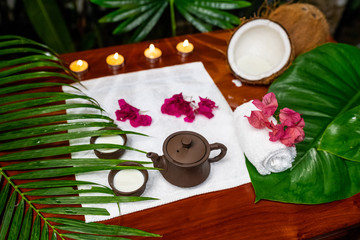 Obraz na płótnie Canvas Tea ceremony located on a white terry towel with candles, coconut flowers