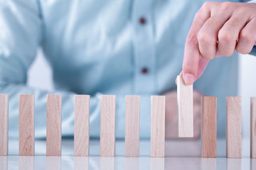 Businessman hand stopping the domino effect for management and Solution , concept strategy and...