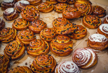 Sweet homemade roll cakes with raisins. Fresh pastry with dry fruits and icing sugar.