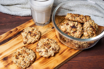 oatmeal cookies with apples and milk on a wooden board