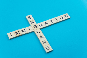 Immigration minimalistic concept. Isolated wooden letter blocks with word cloud Immigration to England