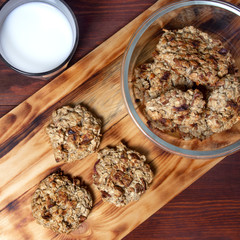oatmeal cookies with apples and milk on a wooden board