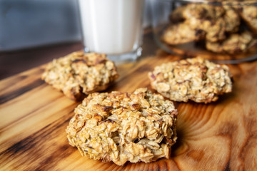oatmeal cookies with apples and milk on a wooden board