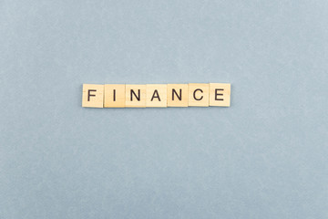 Finance minimalistic concept. Isolated wooden letter blocks with word cloud Finance