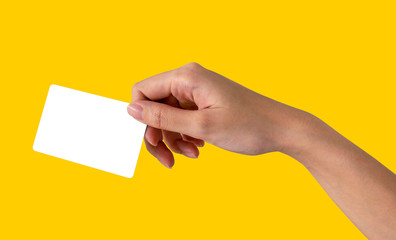 Woman hand hold name card or credit card in right hand with yellow pastel background. with clipping path