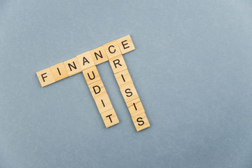 Finance minimalistic concept. Isolated wooden letter blocks with word cloud Finance, Audit and Crisis