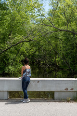 Naklejka na ściany i meble Woman standing on bridge near Swampy river off highway in Virginia
