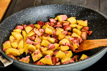 Cooking potato dumpling with bacon on frying pan