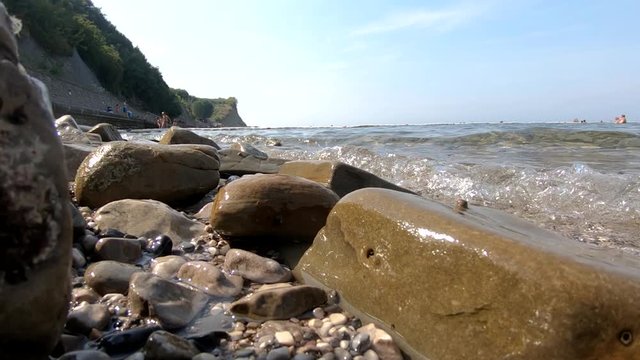 Low angle sea waves hitting rocky shore