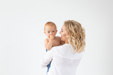 Childhood, motherhood and family concept - Portrait happy mother holds her baby on white background with copy space