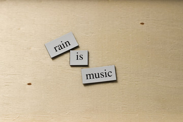 Inspirational text on wooden background, rain is music