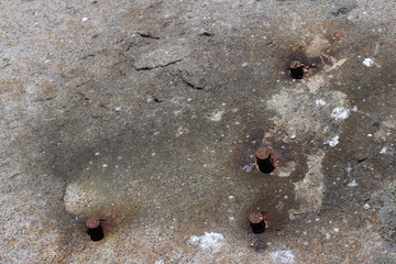 Background with rusty iron bolts in stone
